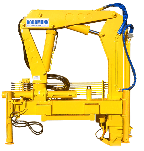 Imagem de produto do guindaste Rodomunk GRM 4000 (cor amarela), braço articulado recolhido, cilindros hidráulicos e mangueiras aparentes, base de fixação e componentes do conjunto em recorte (fundo transparente/escuro).