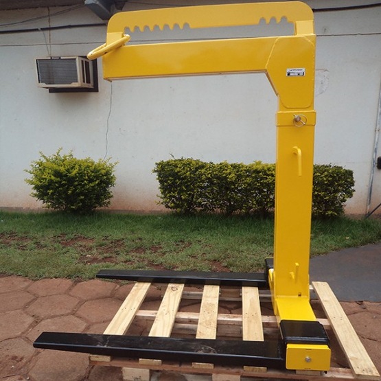 acessório “garfo para pallet” Rodomunk (tipo garfos de empilhadeira) acoplado ao guindaste, feito para levantar e transportar pallets de materiais como telhas e itens de construção, substituindo a necessidade de empilhadeira em muitos cenários.