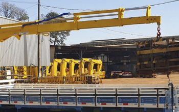 Guindaste articulado em caminhão em área industrial, equipamento usado em operações de içamento que exigem manutenção preventiva para manter desempenho e segurança.
