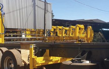 Guindaste articulado em caminhão em área industrial, equipamento usado em operações de içamento que exigem manutenção preventiva para manter desempenho e segurança.