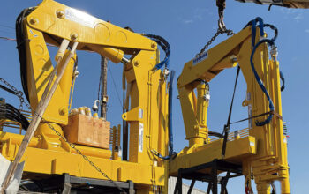 Guindastes veiculares articulados sendo montados em ambiente industrial, destacando a robustez estrutural, os braços hidráulicos e o acabamento industrial que reforçam a importância da qualidade de fabricação na escolha do fabricante.